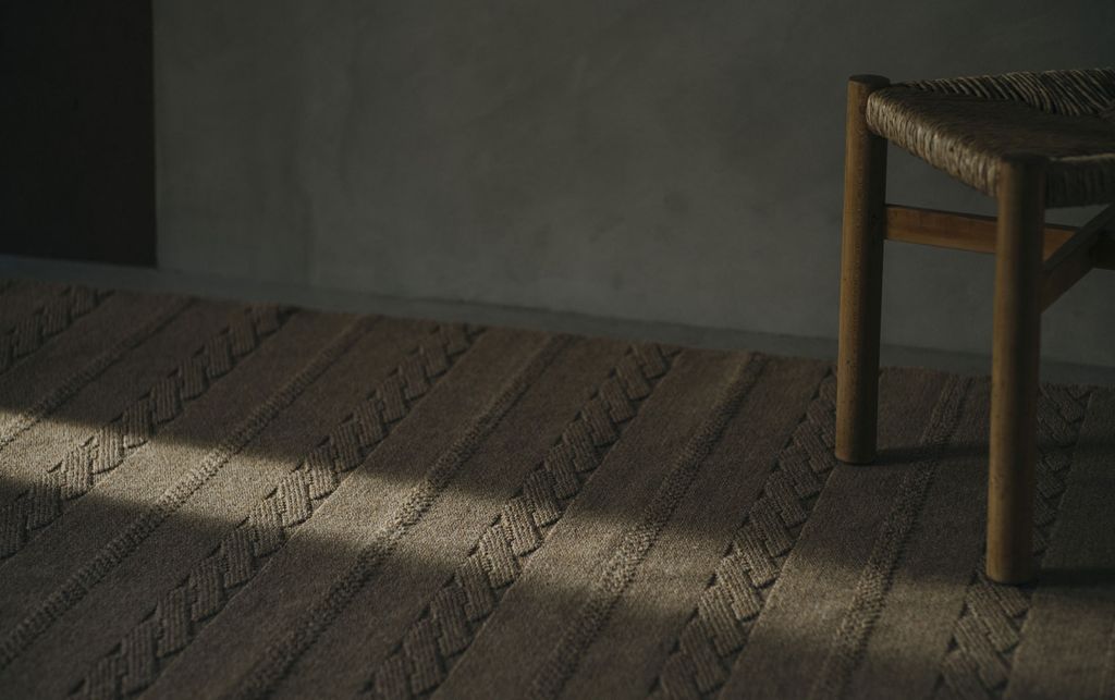 床に敷かれているブラウンのWOOLRUGに光が当たっている画像